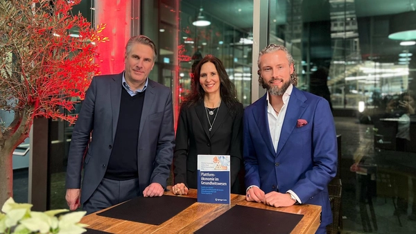 Three people presenting a book