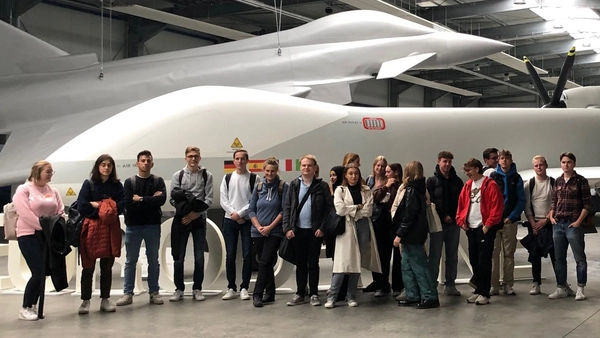 Studierende stehen in der Werkshalle von Airbus vor zwei Jets