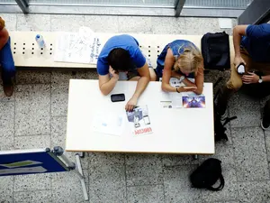 Draufsicht Studierende an Tisch in der Aula