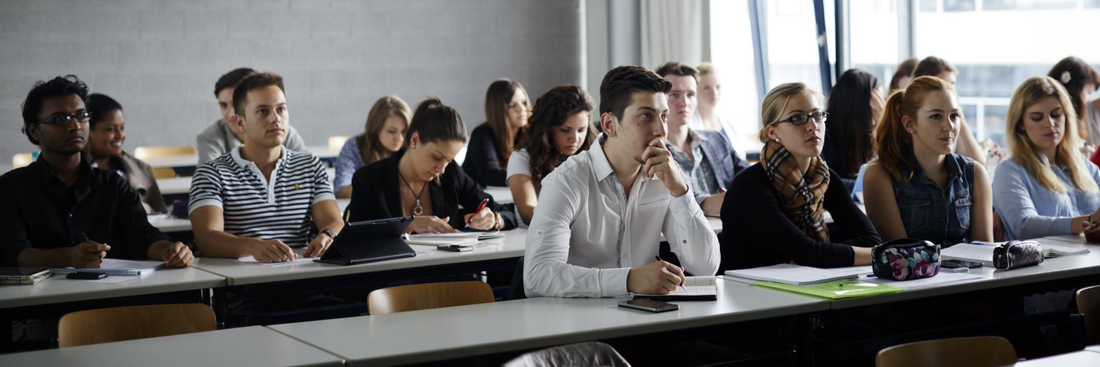 Students sit in three rows in a lecture