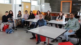 Studierende sitzen in einer Reihe mit Gastdozent Martin Petroll im Retail Lab der THI Business School