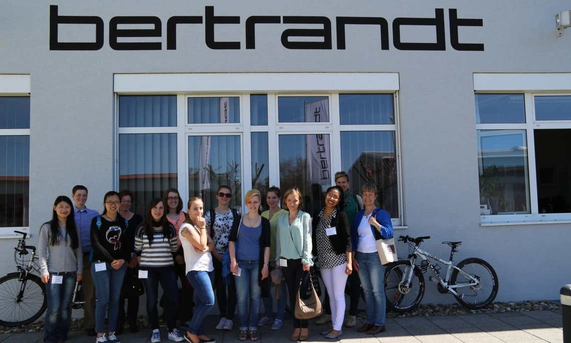 Eine Gruppe Studentinnen steht vor dem Firmengebäude von Bertrandt