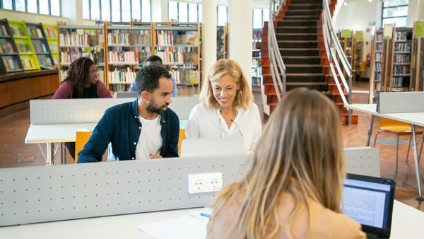 Menschen sitzen in einer Bibliothek