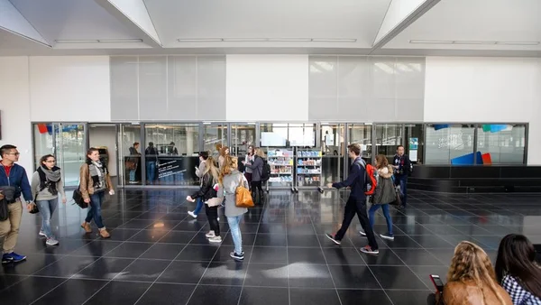 Menschen gehen in Aula der Hochschule