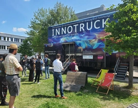 Innotruck auf Campuswiese mit Menschen davor