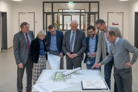 Oberbürgermeister Dr. Bernhard Gmehling, Dekanin Professor Jana Bochert, Kanzler Christian Müller, THI-Präsident Professor Walter Schober, Standortleiter Stefan Hoiczyk, der Leiter des Staatlichen Hochbauamts Thomas Sendtner und Prodekan Professor Oliver Blask (v.l.n.r.) sind sichtlich angetan von den hochattraktiven Entwürfen (Fo-to: THI).