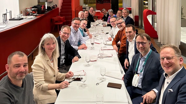 Eine Gruppe Menschen sitzt an einer langen Tafel in einem Restaurant.