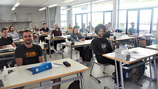 Gruppenfoto Frauen und Männer in Vorlesungsraum